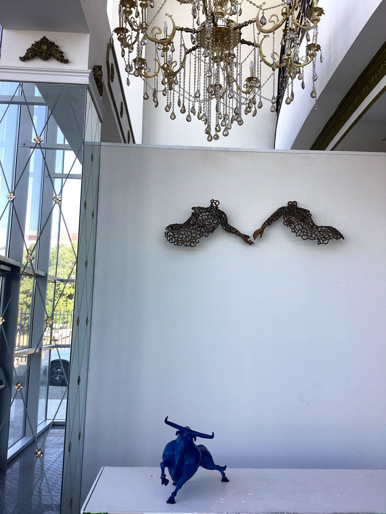 a table with sculptures and art on the wall